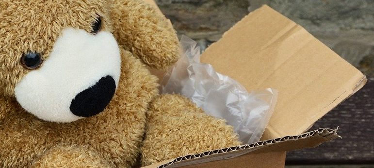 a teddy bear in a cardboard box