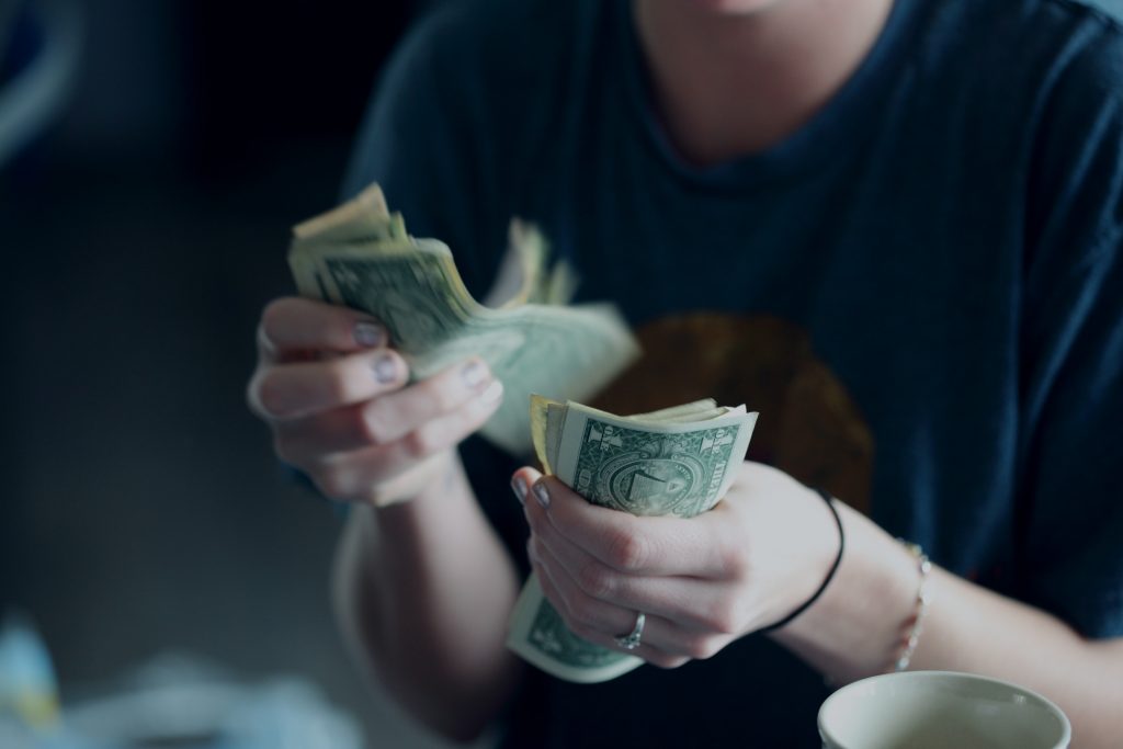 Girl counting money for cheapest ways to relocate